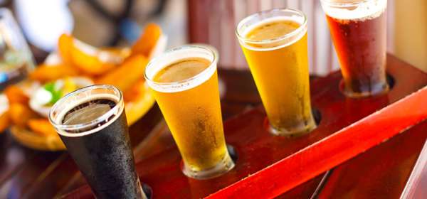 Four glasses of beer on a wooden board