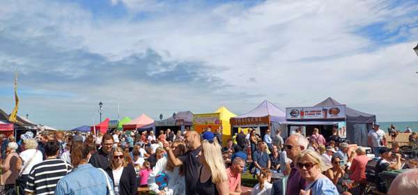 A crowd of people in front of food and drink stalls