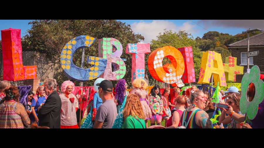 Colourful letters LGBTQIA+ and a crowd 