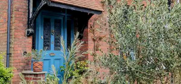 The front view of The Dover Stop, a Victorian house with a blue period door.