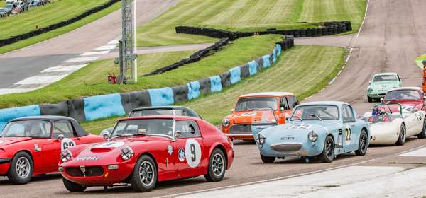 Racing cars on a circular track racing against each other.