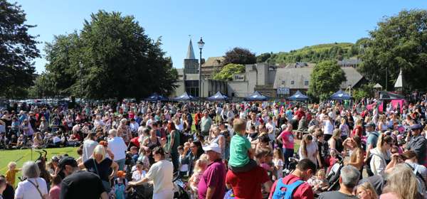 A crowd of adults and children in summer in Pencester Gardens.