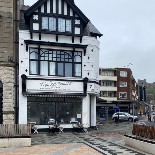 Black and white exterior of Market Square Kitchen in Dover with the castle in the background