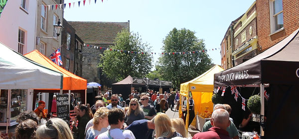 A bustling street market in the summer sunshine 