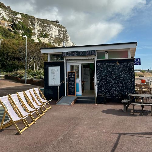 Outside view of Rebels Dover with deck chairs and the white cliffs in the background.