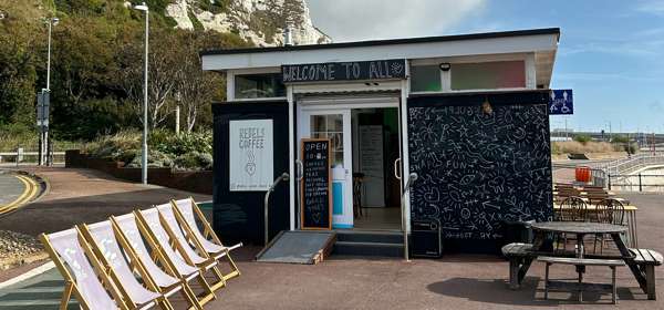 Outside view of Rebels Dover with deck chairs and the white cliffs in the background.