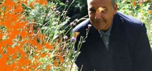 Photo of Rob Newman posing in a garden with flowers